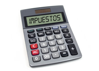 Calculator with the spanish word for tax - impuestos isolated